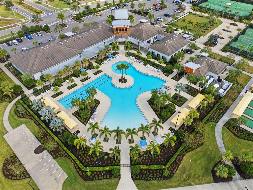 An aerial view shows a community clubhouse with a large swimming pool and tennis courts — 31524 MAGNA GOLF LOOP, SAN ANTONIO, FL