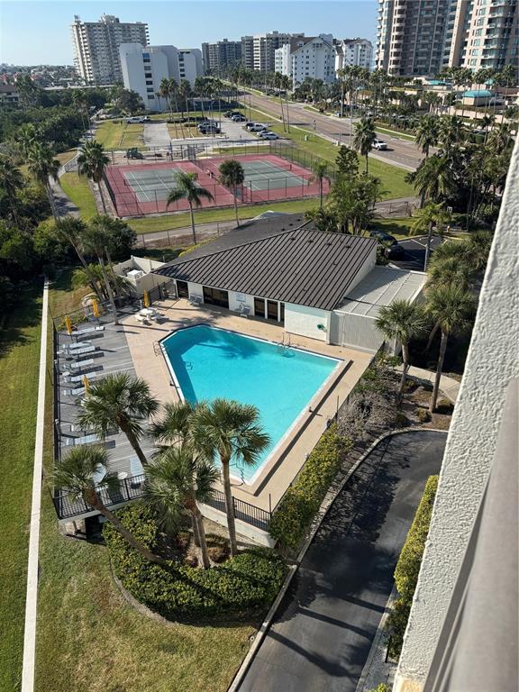 An aerial view shows a swimming pool, clubhouse, tennis courts, and surrounding residential buildings — 1501 GULF BOULEVARD UNIT 603, CLEARWATER BEACH, FL