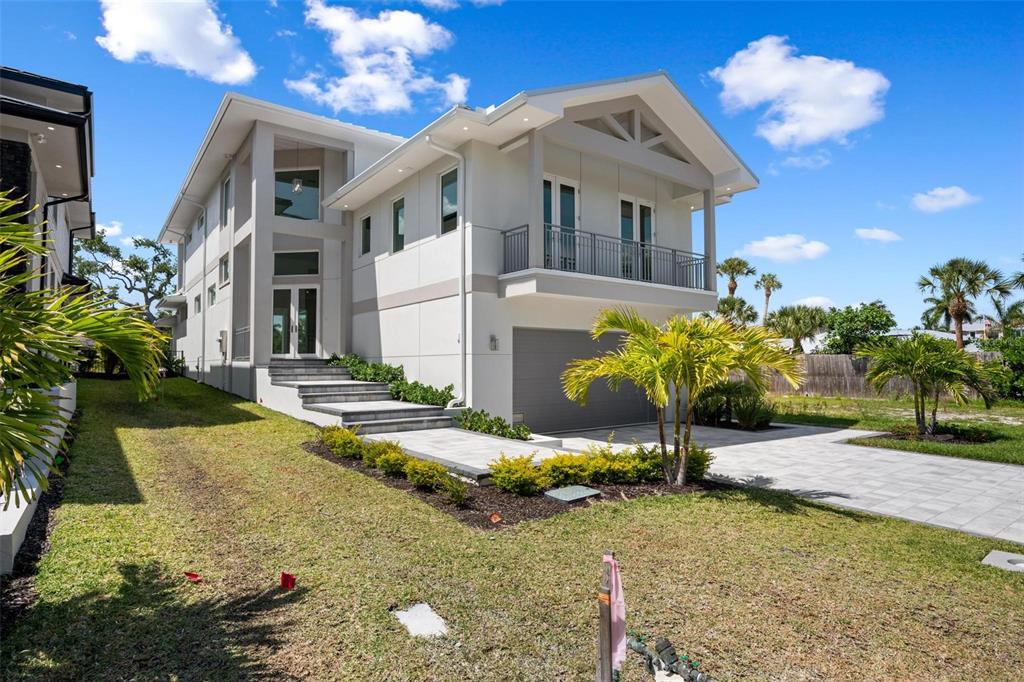 A two-story modern house with a gray garage, a balcony, and a paved walkway — 533 VENICE LANE, SARASOTA, FL