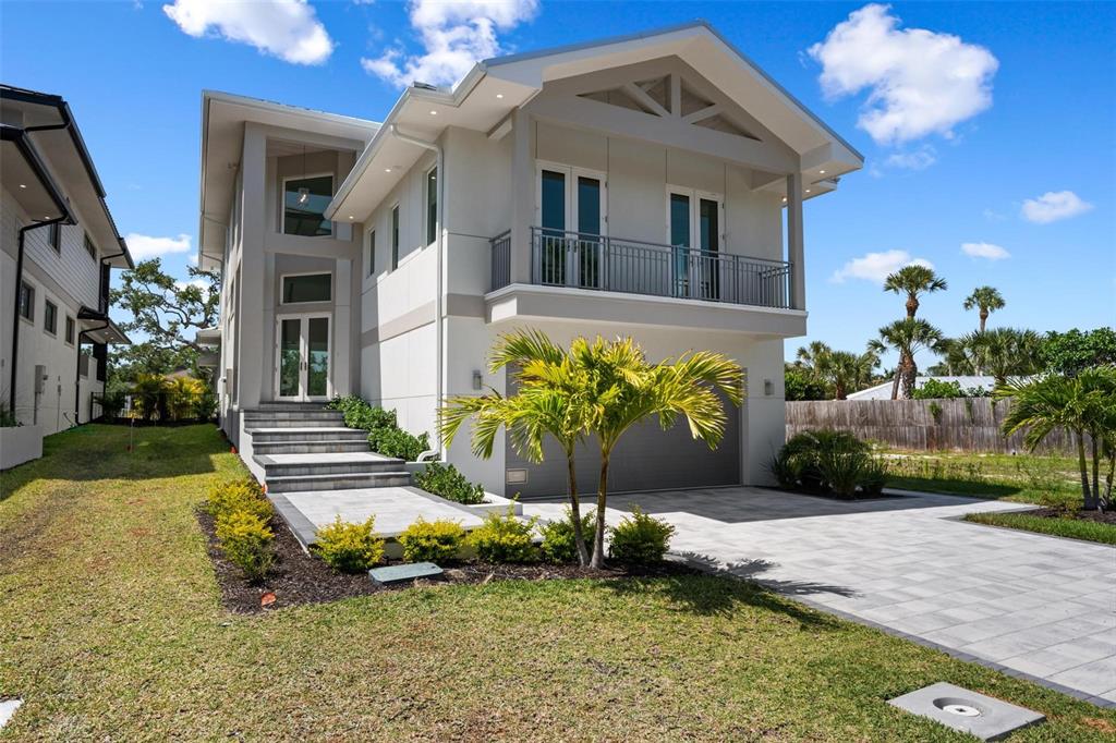 A modern two-story house with a gray garage, a balcony, and stone steps leading up — 533 VENICE LANE, SARASOTA, FL