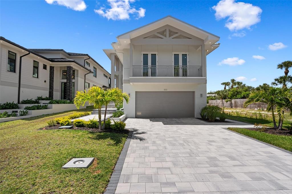A two-story house with a gray garage door, a balcony, and a paved driveway — 533 VENICE LANE, SARASOTA, FL