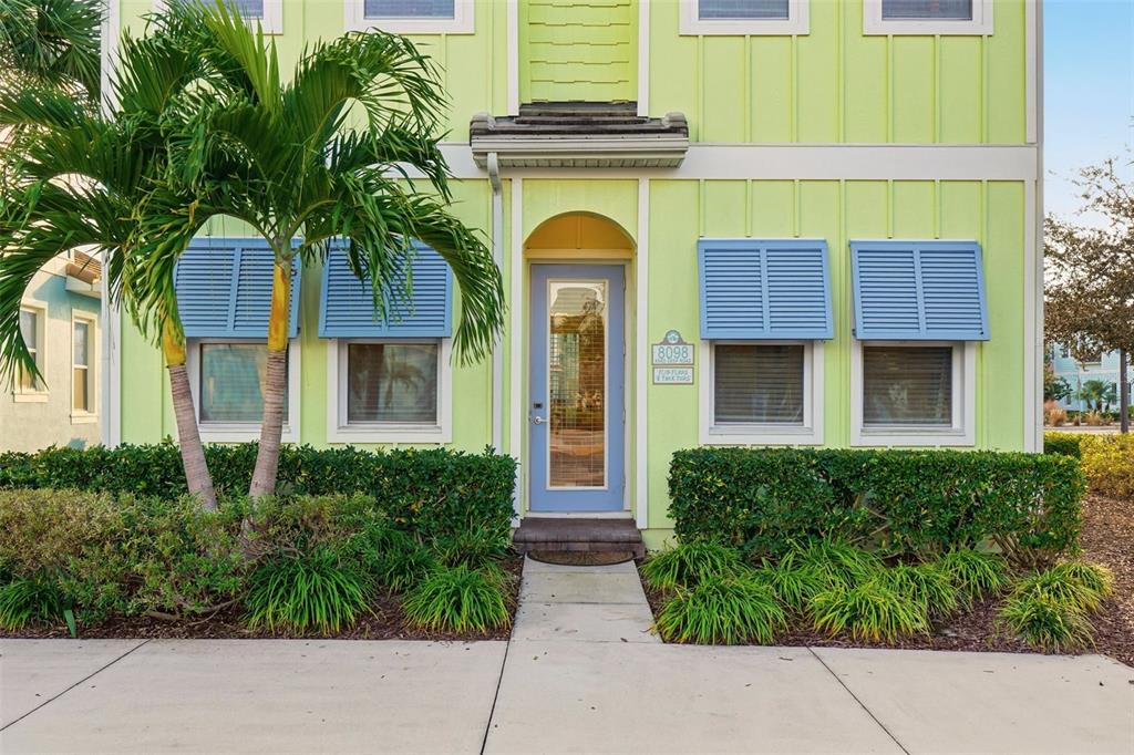 A light green two-story house features a blue front door and matching window shutters — 8098 KNEE DEEP ROAD, KISSIMMEE, FL