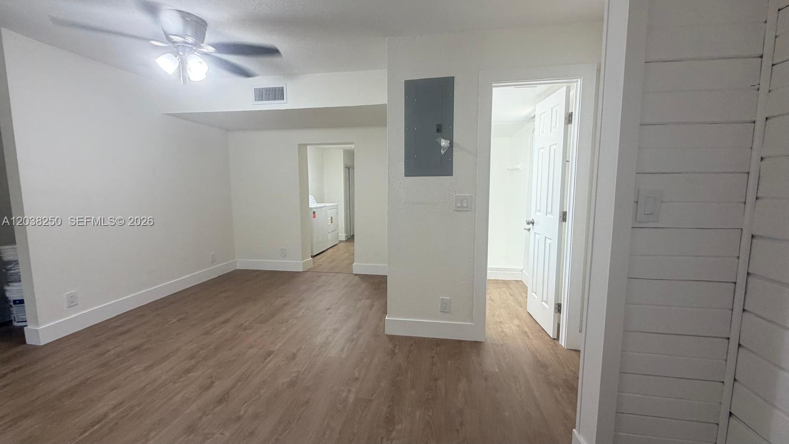 An interior room features wood-look flooring, a ceiling fan, and doorways leading to a closet and laundry area — 2580 NW 62nd Ave, Margate FL 33063, MARGATE, FL