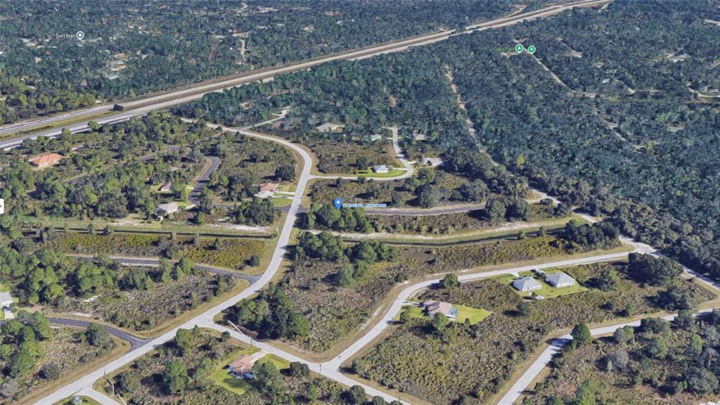 An aerial view shows a vacant residential lot surrounded by trees and paved roads — LARATONDA ROAD Lot 27, NORTH PORT, FL