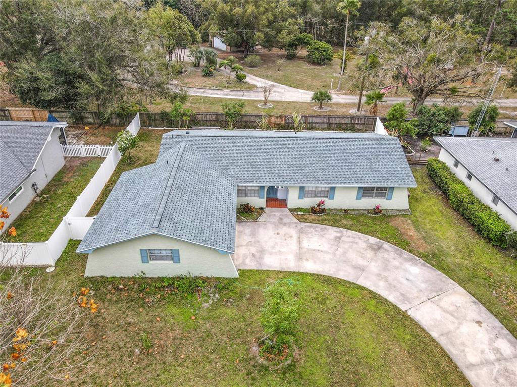 An aerial view of a single-story house with a gray shingled roof and driveway — 1818 IRLO DRIVE, KISSIMMEE, FL