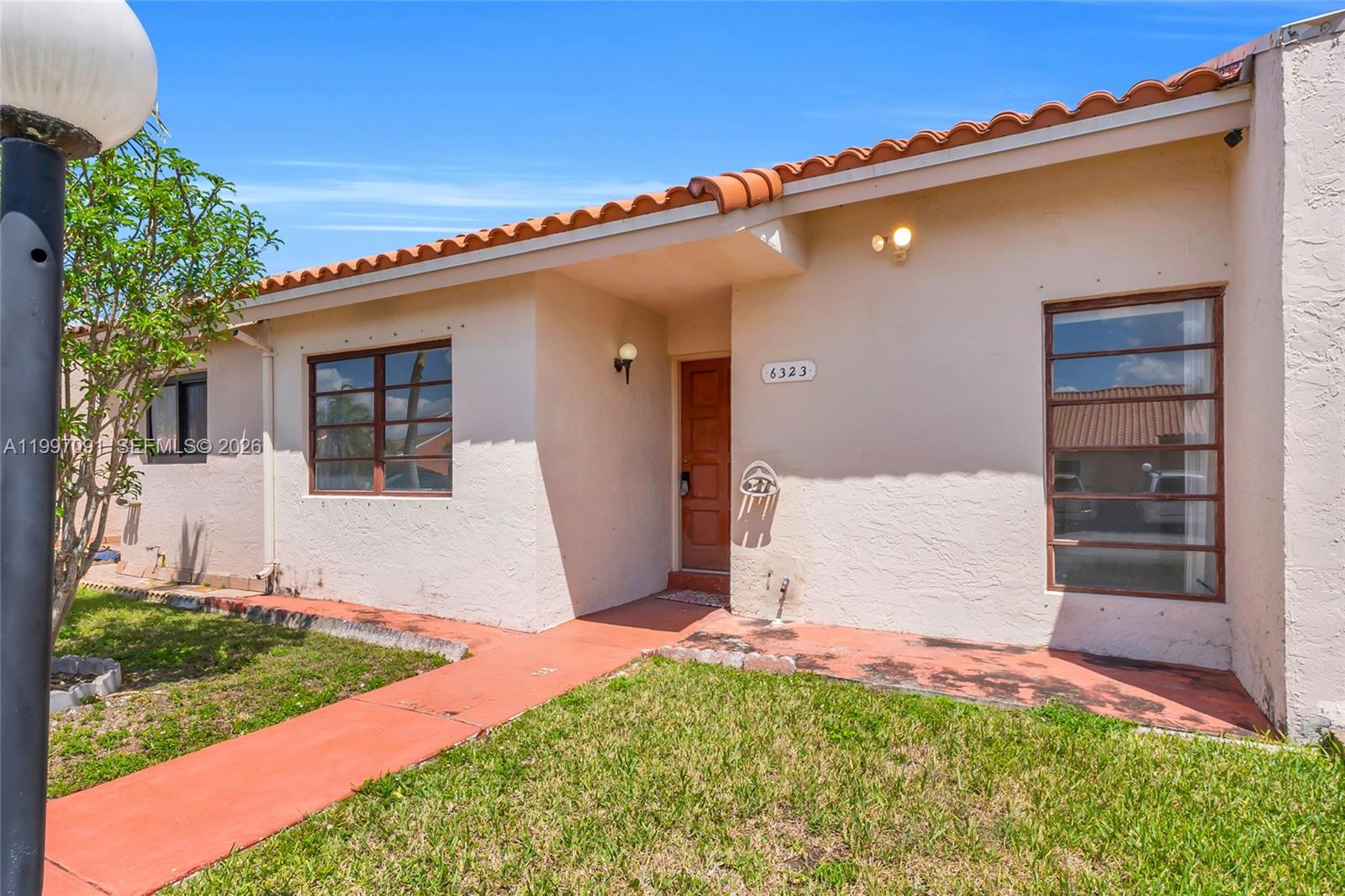 A single-story house with a stucco exterior, red tile roof, and a front walkway — 6323 SW 147th Place Cir, Miami FL 33193, MIAMI, FL