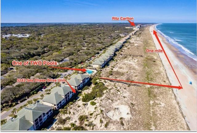 This aerial view shows a coastal residential complex with pools and beach access — 5242 SEA CHASE DRIVE DRIVE UNIT 1, FERNANDINA BEACH, FL