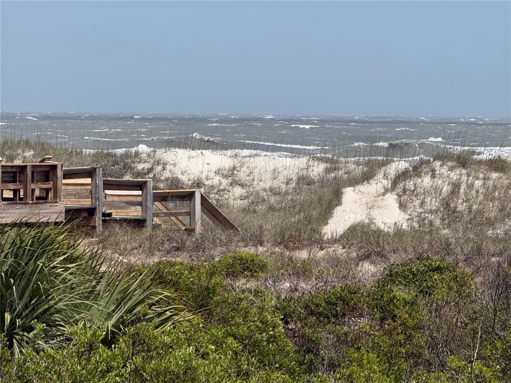 A wooden staircase leads through sand dunes toward a choppy ocean under a clear sky — 5242 SEA CHASE DRIVE DRIVE UNIT 1, FERNANDINA BEACH, FL