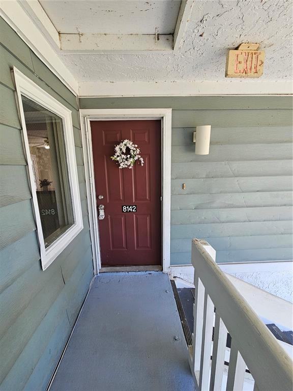 An exterior view of a red front door with a wreath and unit number 8142 — 8142 FAIRWAYS CIRCLE UNIT S204, OCALA, FL