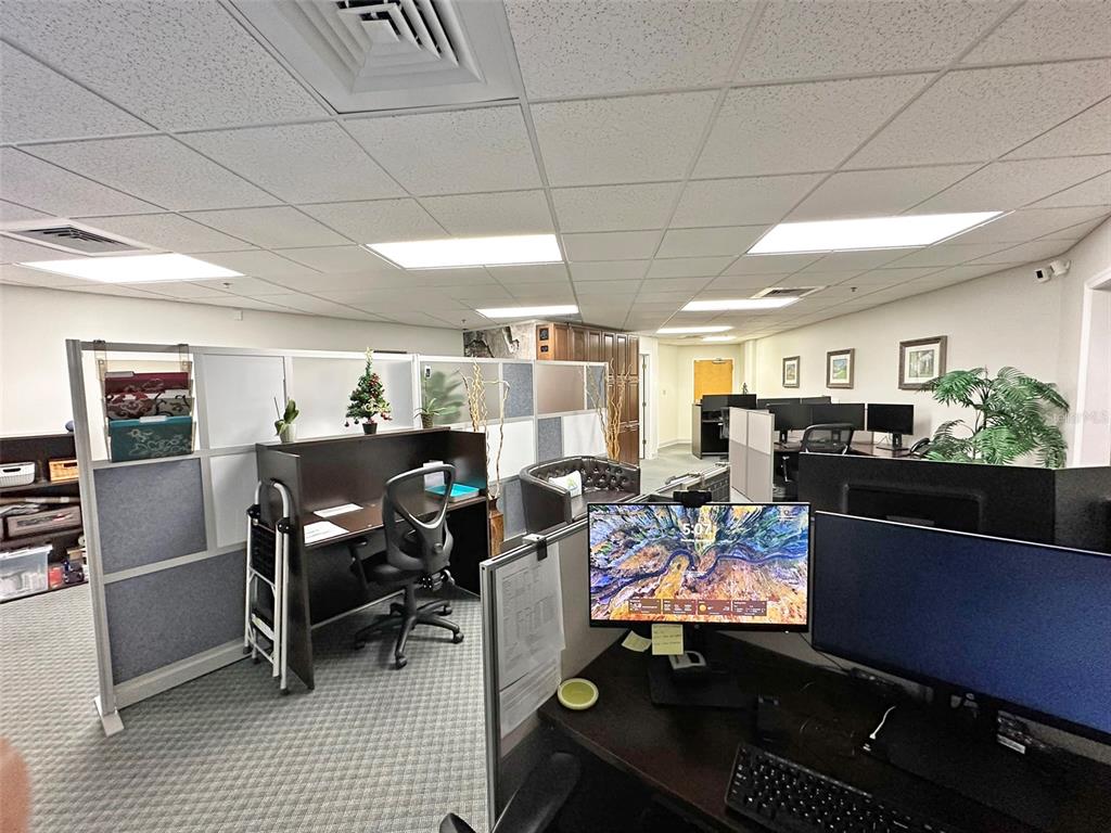 An office space featuring cubicle workstations, a drop ceiling with recessed lighting, and carpeted flooring — 7800 KINGSPOINTE PARKWAY UNIT 102, ORLANDO, FL