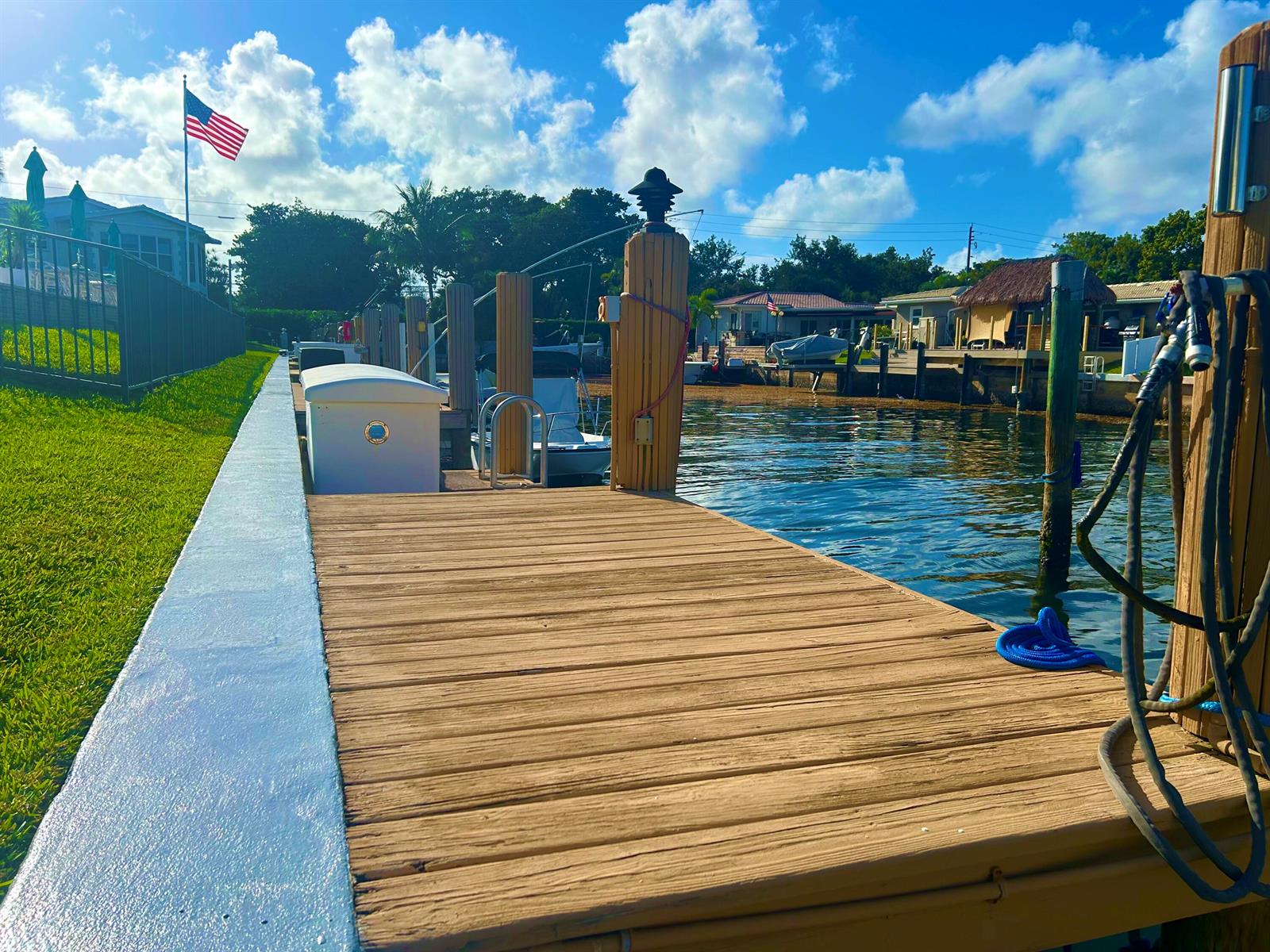 A wooden boat dock extends over the water with a grassy lawn and houses nearby — 701 NE Harbour Terrace # 2140, Boca Raton FL 33431, BOCA RATON, FL