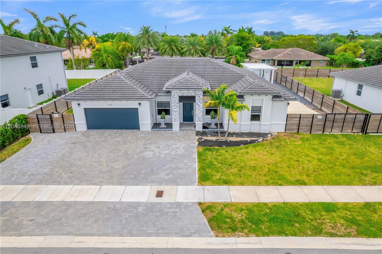 An aerial view of a single-story house with a gray tile roof and paver driveway — 21100 SW 127th Pl, Miami FL 33177, MIAMI, FL