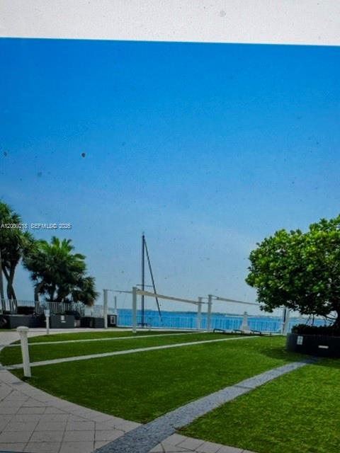 A grassy lawn overlooks a bay with a sailboat mast visible in the distance — 200 SE 15th Rd, Miami FL 33129, MIAMI, FL