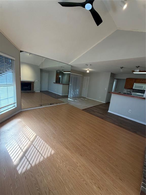 A living room features light wood-look flooring, a vaulted ceiling, and a large mirrored wall — 949 BIRD BAY COURT UNIT 101, LAKE MARY, FL