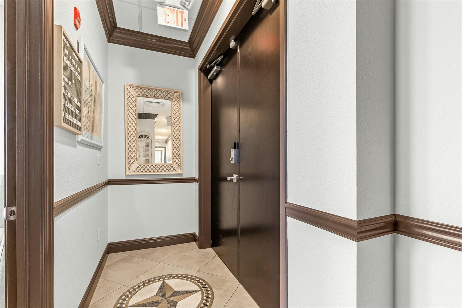 A hallway features a tiled floor with a star inlay, a mirror, and double doors — 3319 S State Rd 7, Wellington FL 33449, WELLINGTON, FL