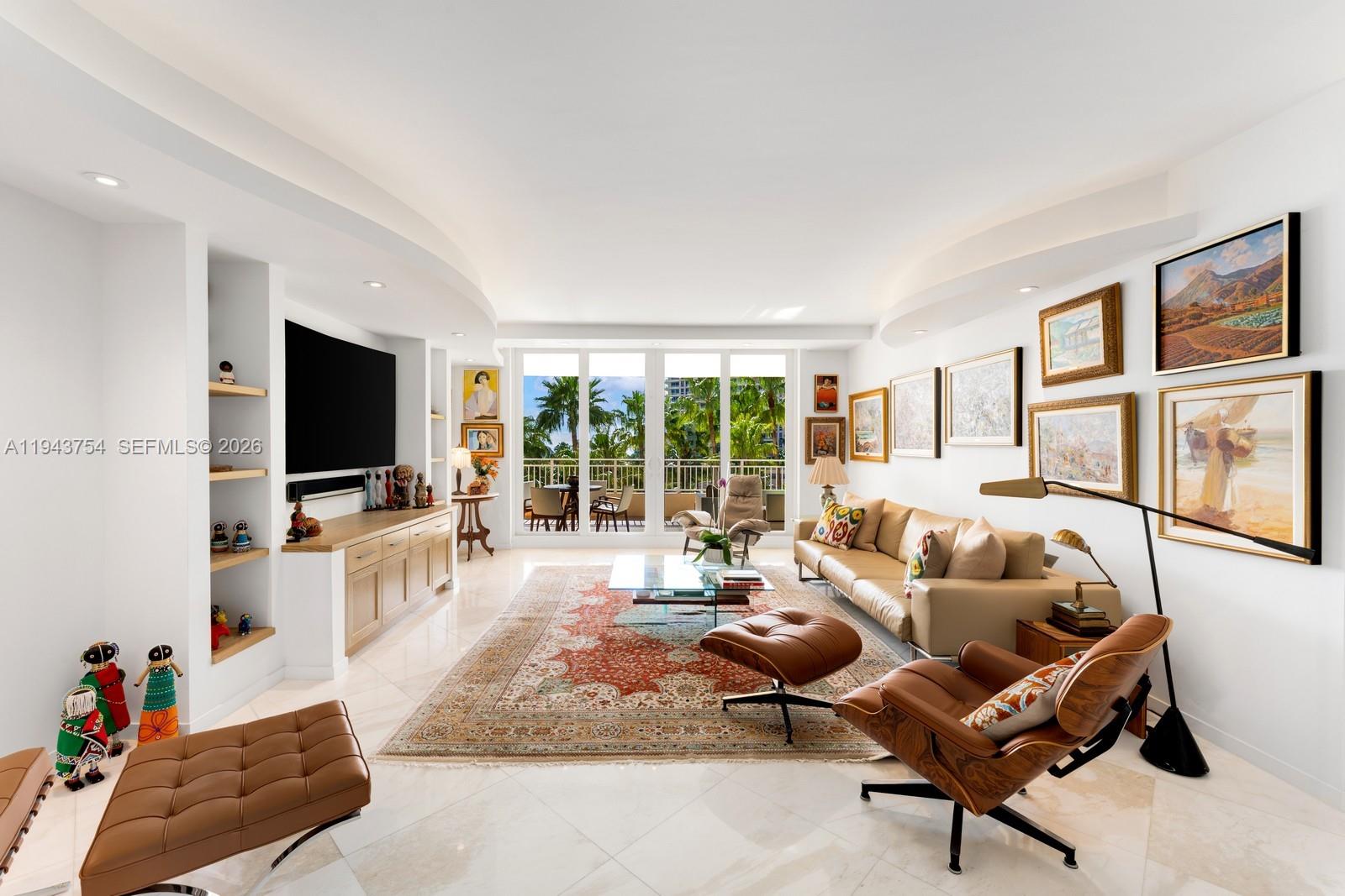 A living room features a beige sofa, leather lounge chairs, a patterned rug, and balcony views — 791 Crandon Blvd # 603, Key Biscayne FL 33149, KEY BISCAYNE, FL