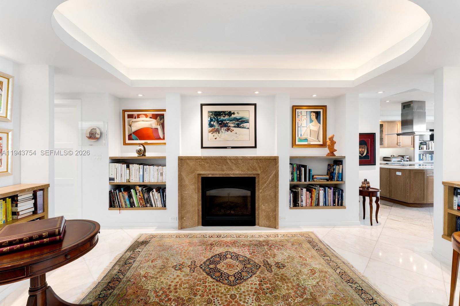 A living room features a marble fireplace, built-in bookshelves, and a large patterned area rug — 791 Crandon Blvd # 603, Key Biscayne FL 33149, KEY BISCAYNE, FL