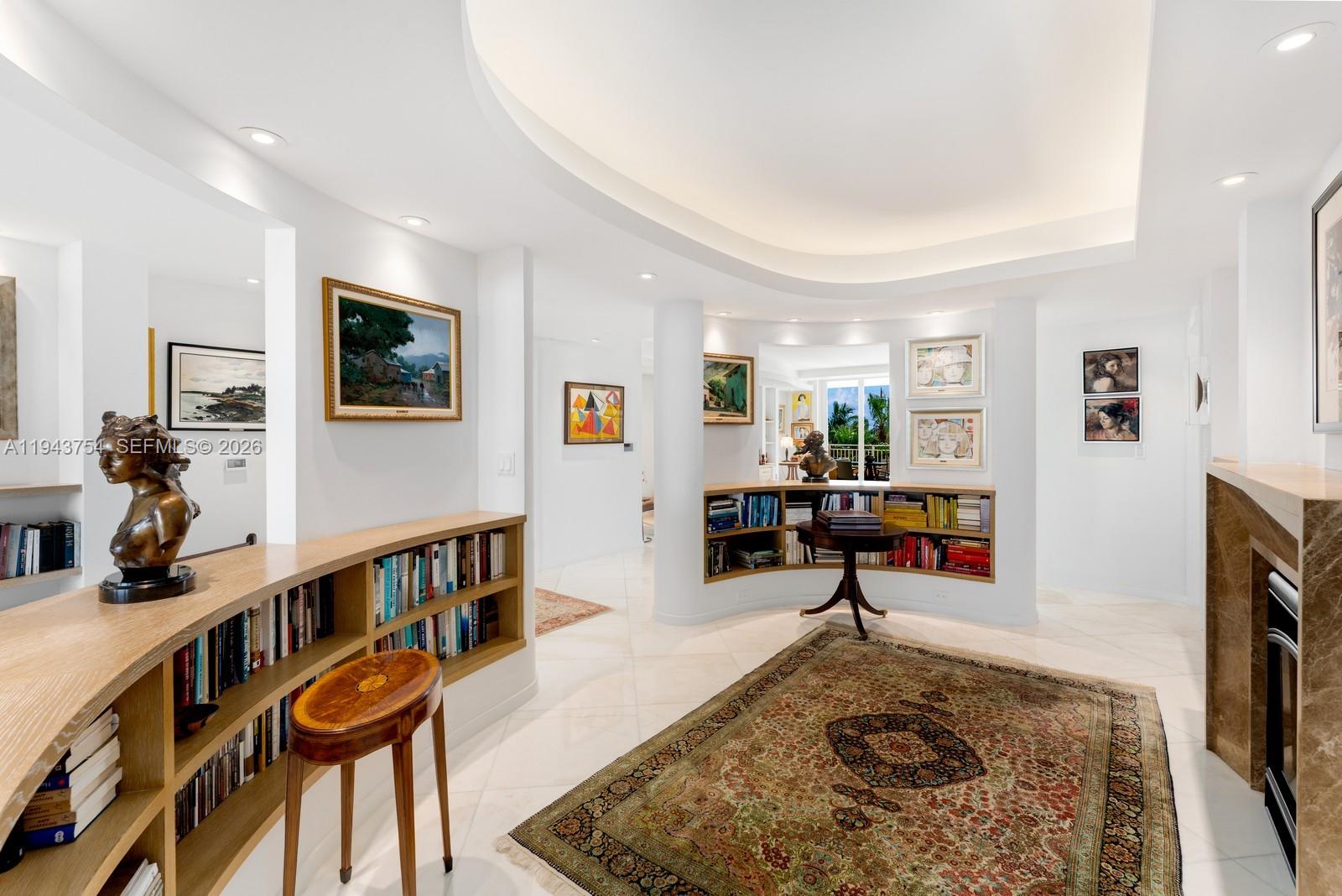 A bright living area features built-in bookshelves, a curved ceiling, and a patterned area rug — 791 Crandon Blvd # 603, Key Biscayne FL 33149, KEY BISCAYNE, FL