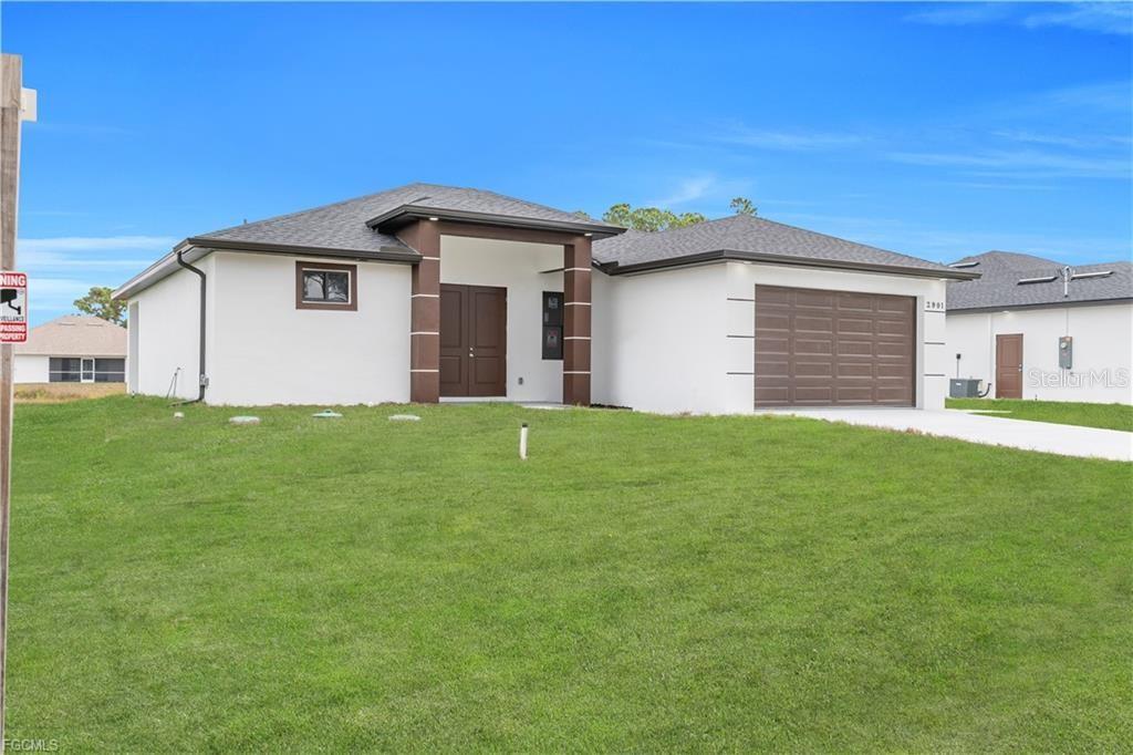 A single-story white house with a brown garage and double front doors sits on grass — 2901 VILLA AVENUE S, LEHIGH ACRES, FL