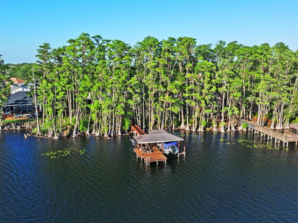 An aerial view of a wooden boat dock with a covered slip on a lake — 21019 MARSH HAWK DRIVE, LAND O LAKES, FL