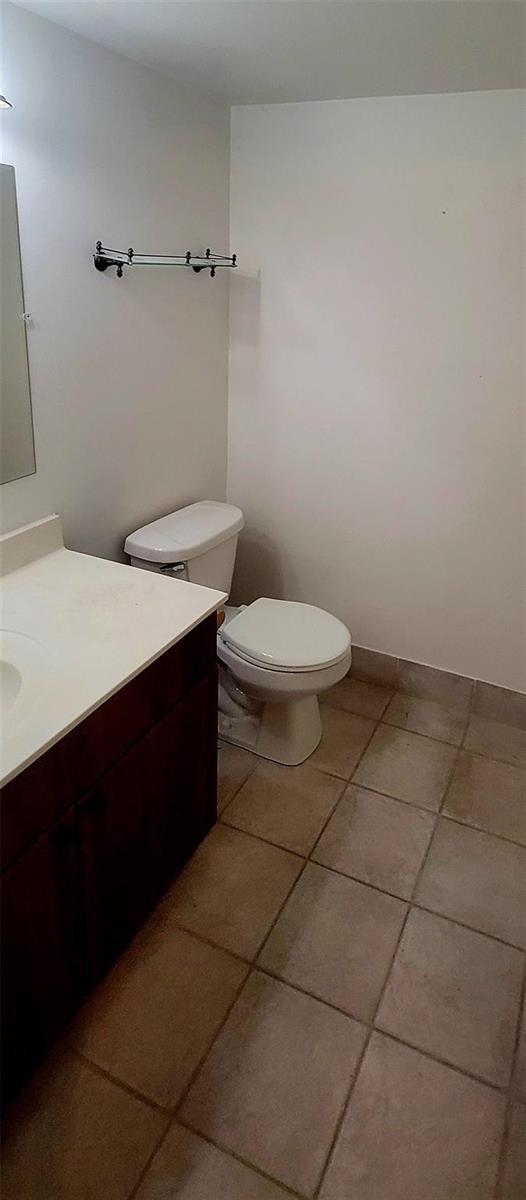 A bathroom features a dark wood vanity, a white toilet, and light-colored floor tiles — 6260 S Falls Circle Drive # 206, Lauderhill FL 33319, LAUDERHILL, FL