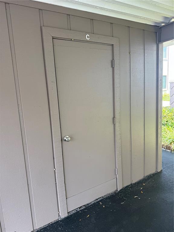 A brown exterior door labeled with the letter C is set into a paneled wall — 514 LONGFELLOW COURT UNIT C, SAFETY HARBOR, FL
