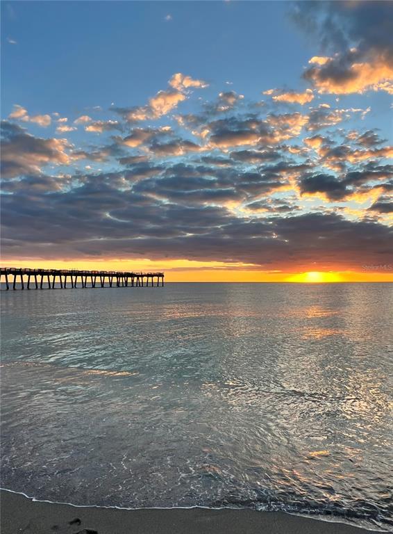 A wooden pier extends into the ocean under a sunset sky with scattered clouds — 8226 DIMSTEAD STREET, PORT CHARLOTTE, FL