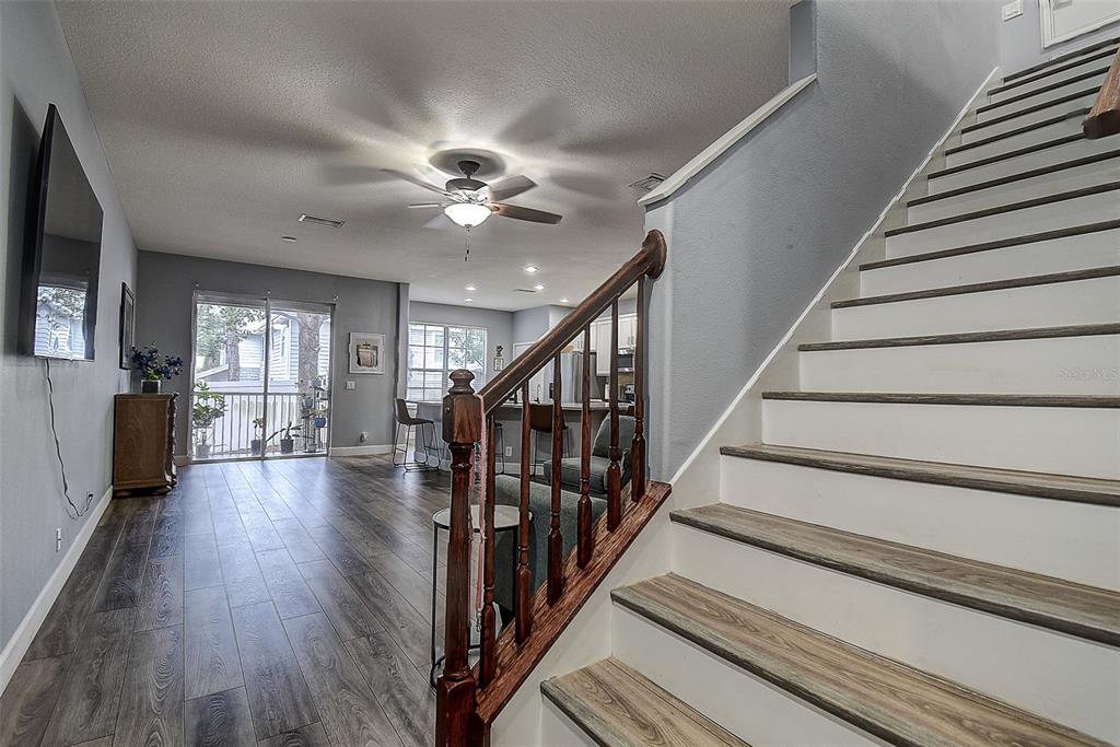 A view from the bottom of a staircase looking into an open-concept living area — 1426 HILLVIEW LANE, TARPON SPRINGS, FL