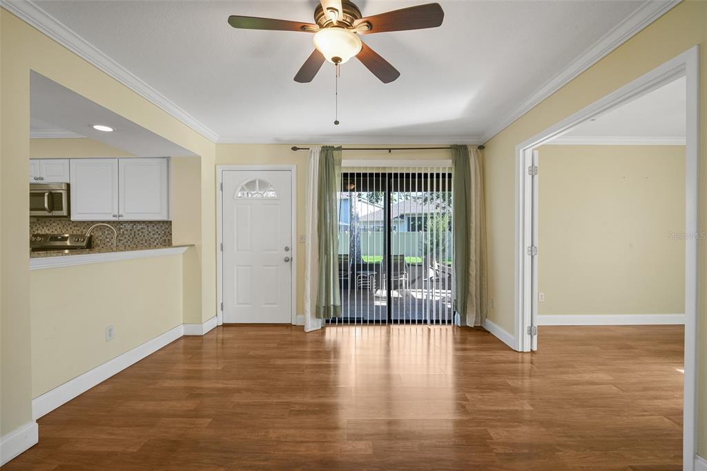 A dining area with wood-look flooring, a ceiling fan, and a sliding glass door — 601 CASA PARK COURT K COURT UNIT K, WINTER SPRINGS, FL