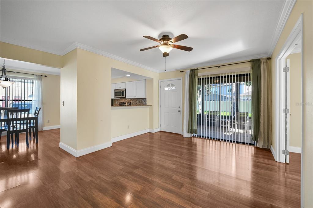 A living area with wood-look flooring, a ceiling fan, and a sliding glass door — 601 CASA PARK COURT K COURT UNIT K, WINTER SPRINGS, FL