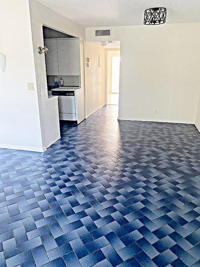 An interior view shows a kitchen with white cabinets and blue basket-weave tile flooring — 408 Grantham A # 408, Deerfield Beach FL 33442, DEERFIELD BEACH, FL