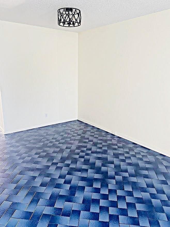 An empty room features white walls and a distinctive blue basket-weave patterned tile floor — 408 Grantham A # 408, Deerfield Beach FL 33442, DEERFIELD BEACH, FL