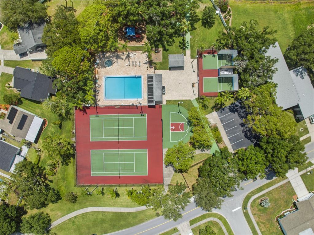 An aerial view shows a community recreation area with tennis courts, a pool, and basketball court — 123 LOBLOLLY COURT UNIT B, OLDSMAR, FL