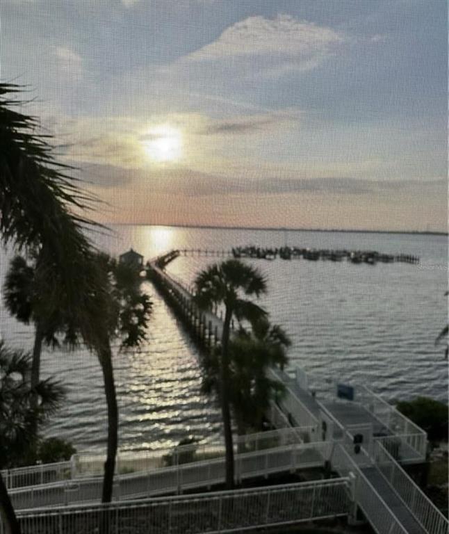 An elevated view of a long wooden pier extending into a calm body of water — 5114 MELBOURNE STREET UNIT A302, PUNTA GORDA, FL