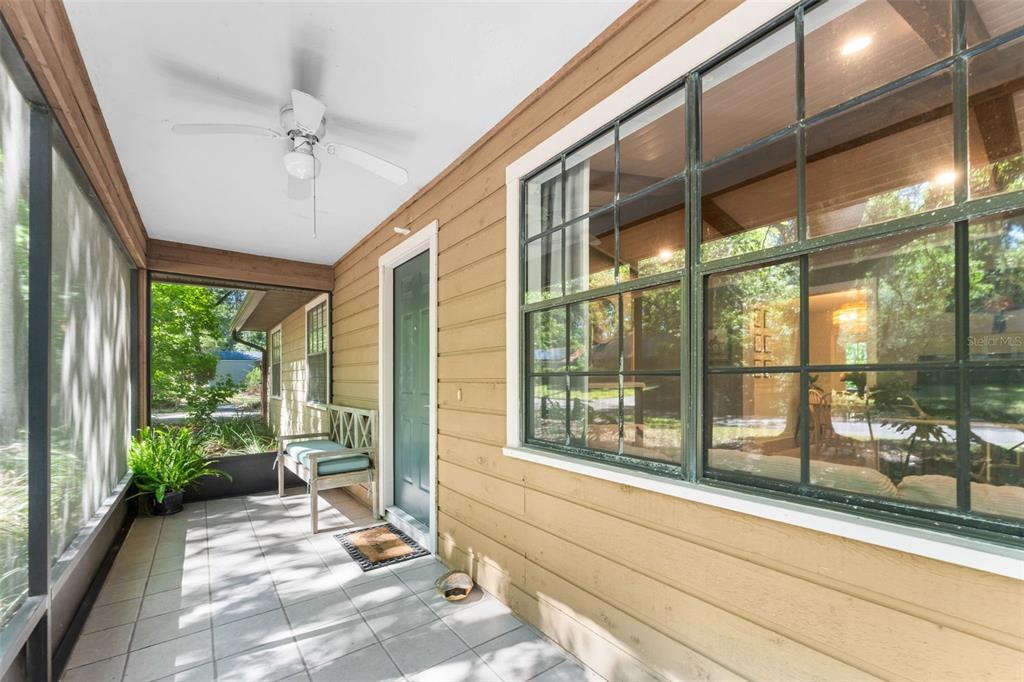 A screened-in porch features tan horizontal siding, a ceiling fan, and a tiled floor — 3724 NW 53RD TERRACE, GAINESVILLE, FL
