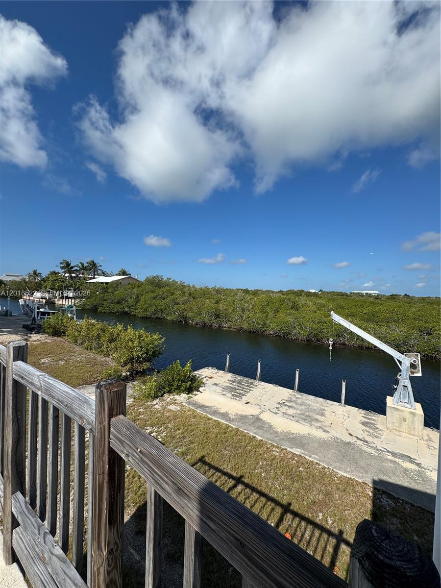 An elevated view of a boat lift on a concrete dock beside a mangrove canal — 4276 Dorn Road, Torch Key FL 33042, TORCH KEY, FL