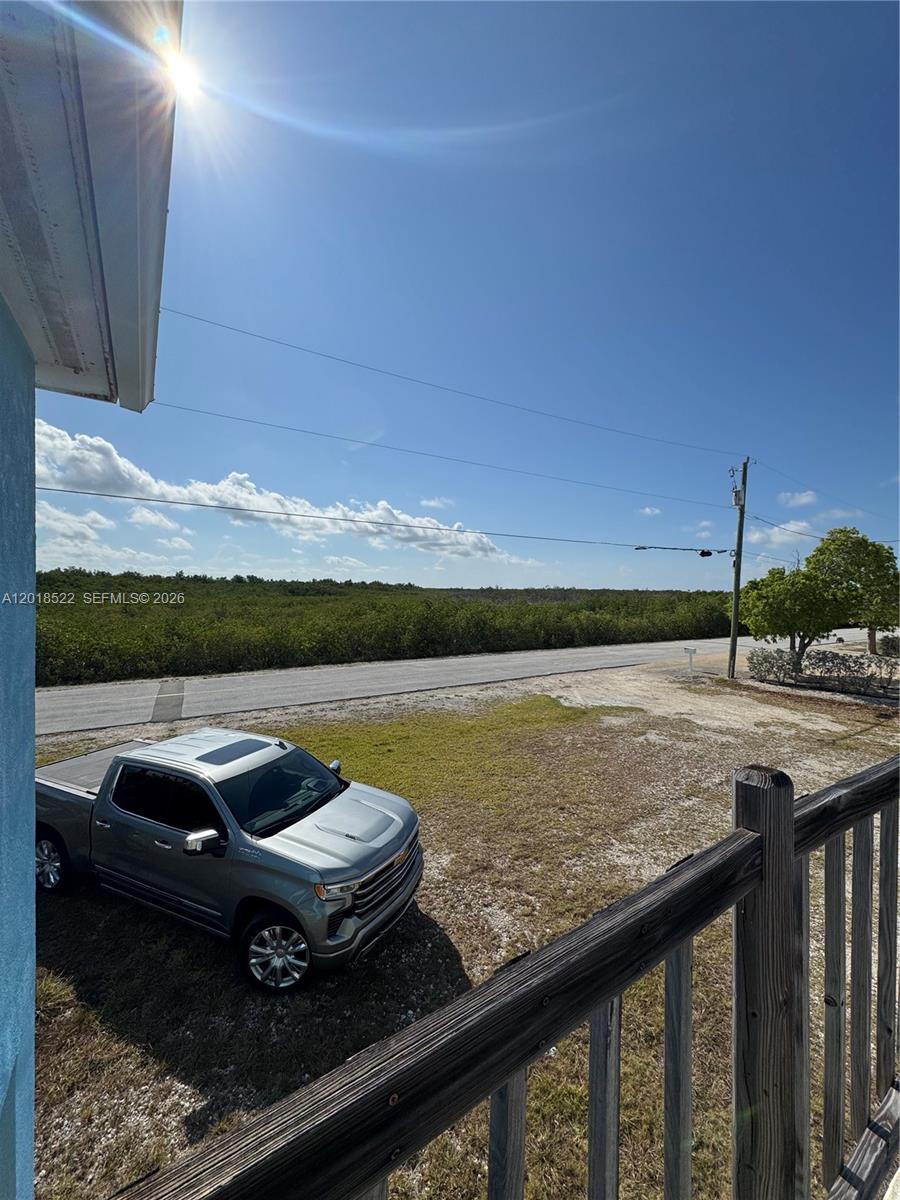 A silver pickup truck is parked on a dirt lot next to a wooden railing — 4276 Dorn Road, Torch Key FL 33042, TORCH KEY, FL