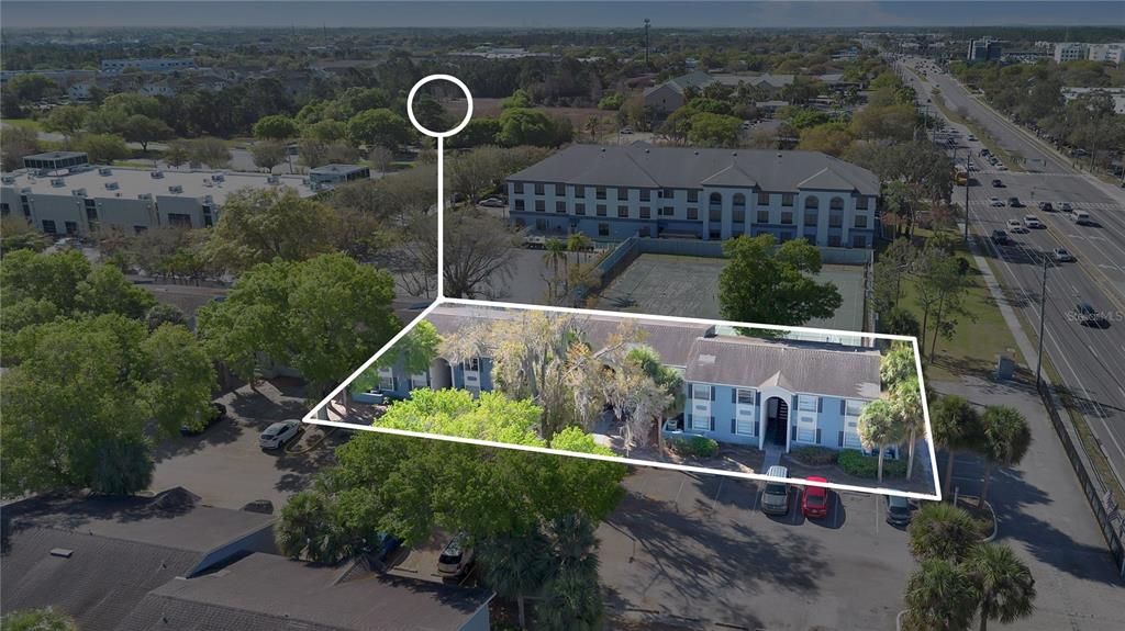 An aerial view shows a blue two-story apartment building surrounded by trees and parking lots — 2507 N ALAFAYA TRAIL UNIT 10, ORLANDO, FL