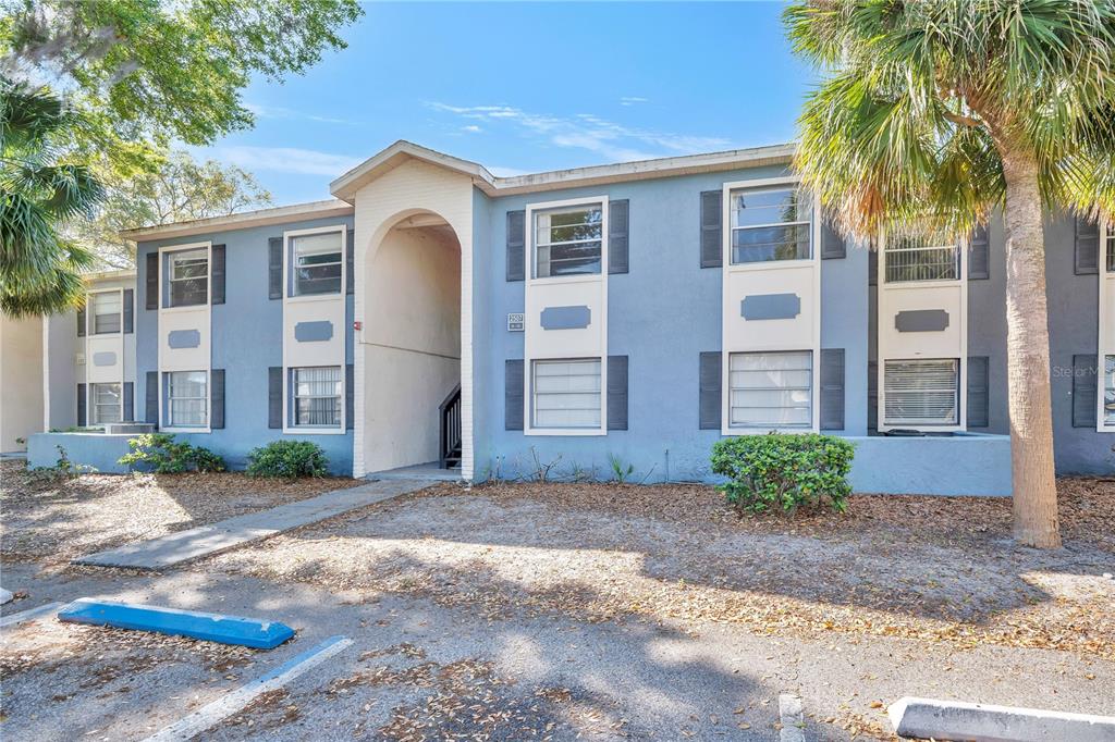 A two-story blue apartment building with an arched entryway and a parking lot in front — 2507 N ALAFAYA TRAIL UNIT 10, ORLANDO, FL