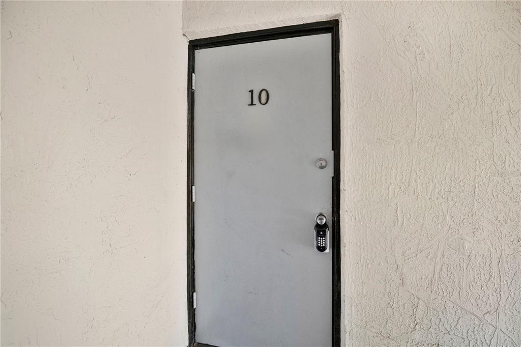A gray door labeled with the number 10 is set into a textured white wall — 2507 N ALAFAYA TRAIL UNIT 10, ORLANDO, FL