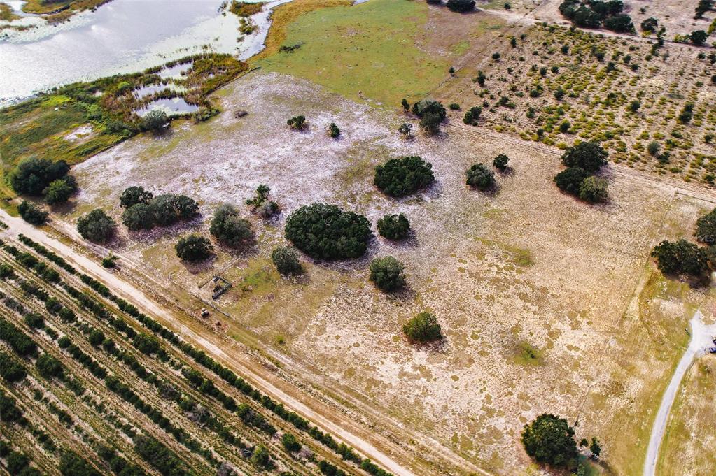An aerial view shows a large, grassy lot with scattered trees and a nearby pond — 0 EDWARDS ROAD UNIT 0, HAINES CITY, FL