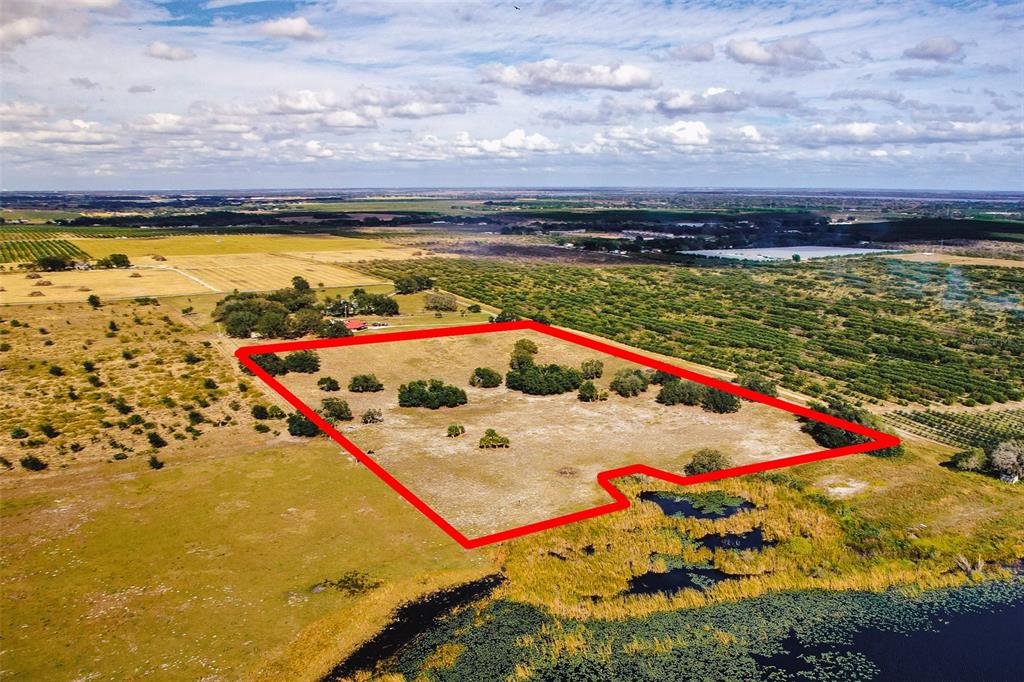 An aerial view shows a large, rectangular plot of land outlined in red near water — 0 EDWARDS ROAD UNIT 0, HAINES CITY, FL