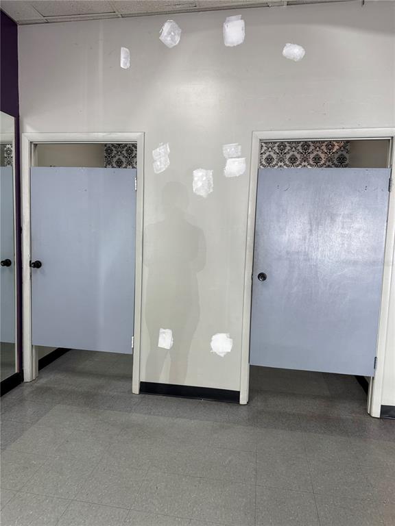 Two gray doors lead into a room with a white wall featuring several patch repairs — 14815 N FLORIDA AVENUE UNIT 14815, TAMPA, FL