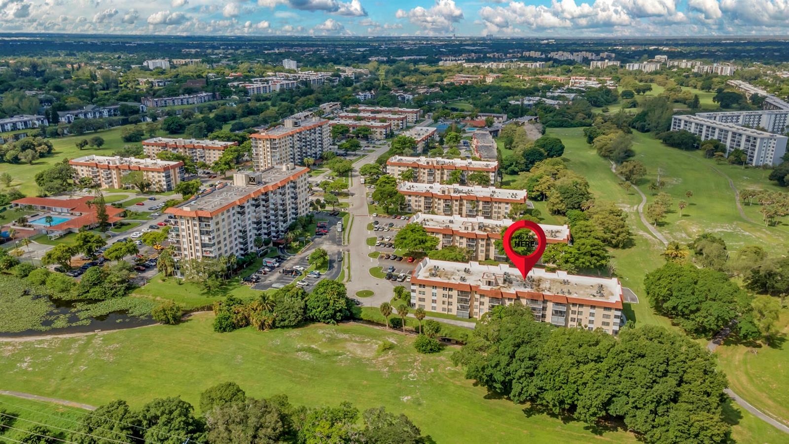 An aerial view shows a multi-story apartment complex surrounded by green lawns and trees — 4166 Inverrary Drive # 304, Lauderhill FL 33319, LAUDERHILL, FL