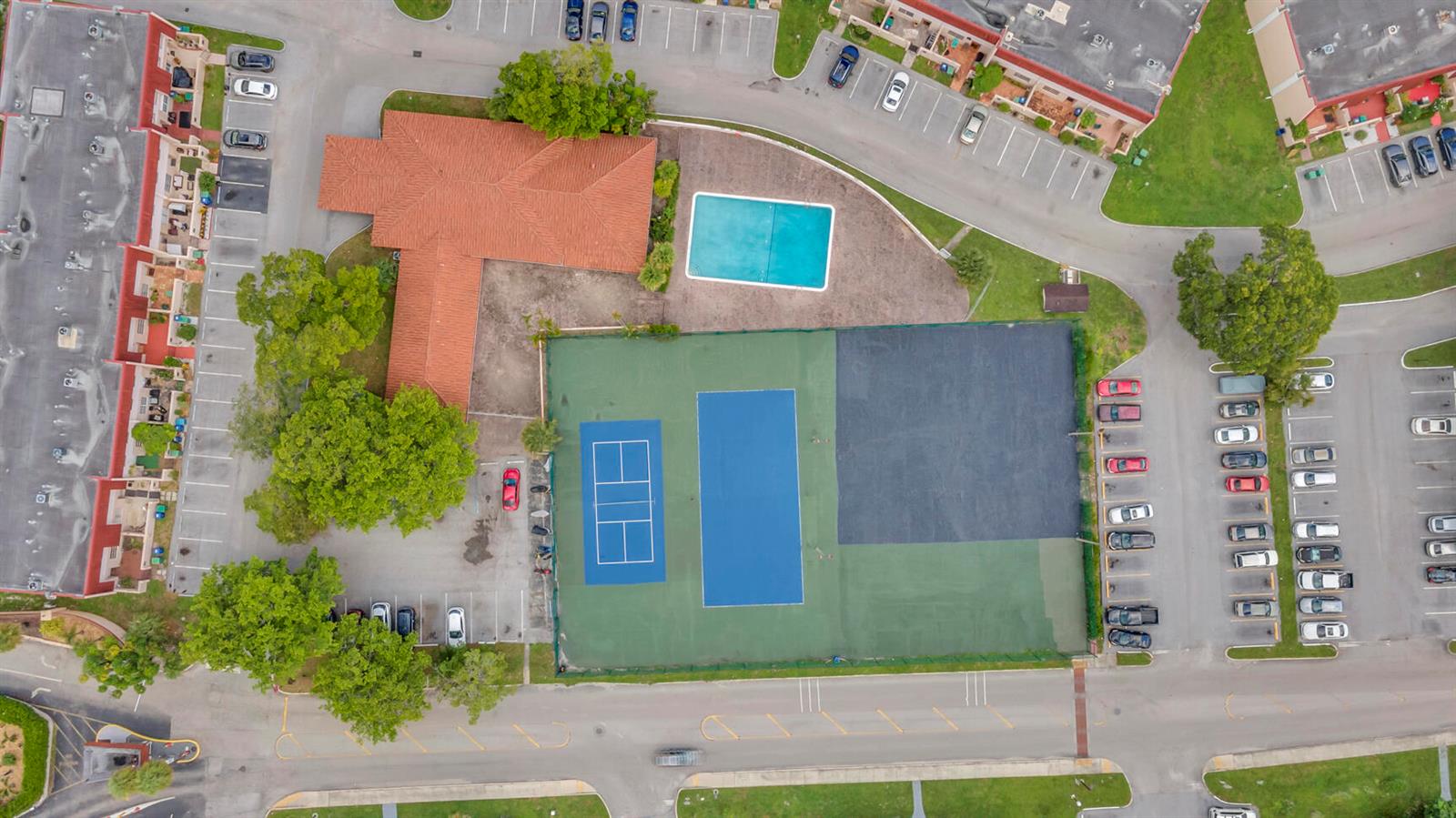 Aerial view of a community center featuring a pool, tennis courts, and parking lots — 4166 Inverrary Drive # 304, Lauderhill FL 33319, LAUDERHILL, FL