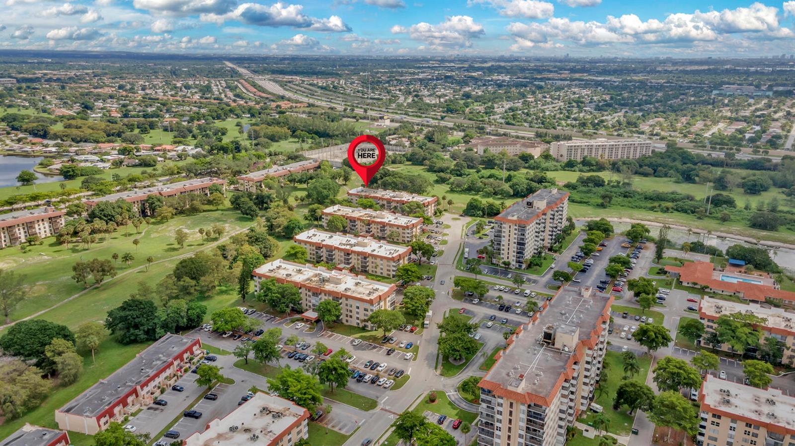 An aerial view shows several multi-story apartment buildings surrounded by parking lots and green space — 4166 Inverrary Drive # 304, Lauderhill FL 33319, LAUDERHILL, FL