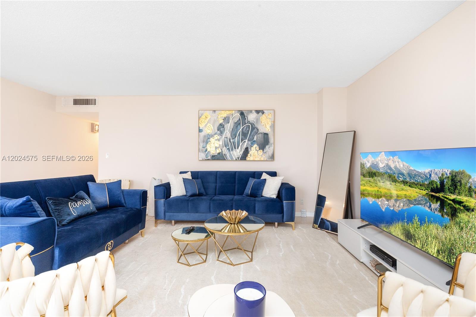 A living room features two blue velvet sofas, gold-accented coffee tables, and a large television — 2030 S Ocean Dr # 307, Hallandale Beach FL 33009, HALLANDALE BEACH, FL