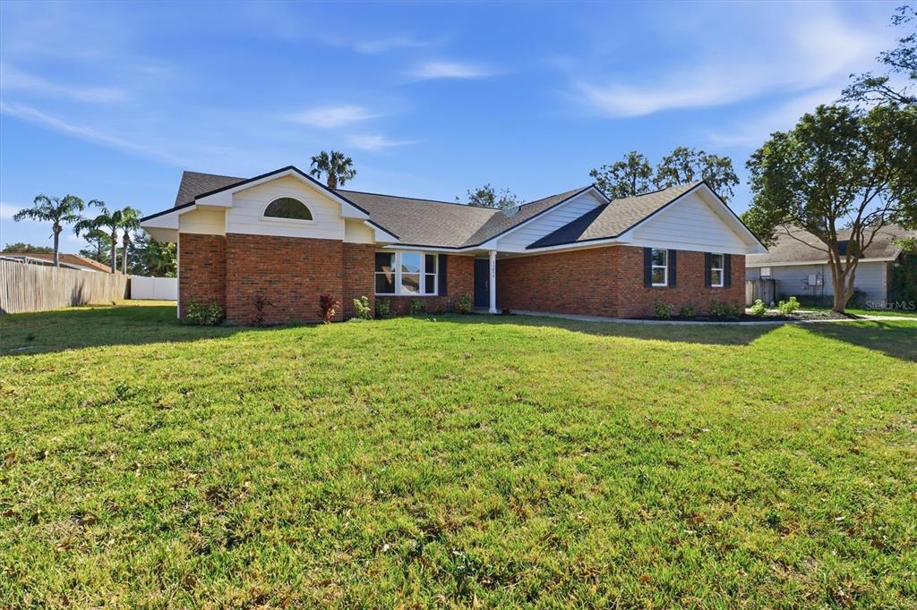 A single-story brick house with a gabled roof and a large front lawn — 33608 OVERTON DRIVE, LEESBURG, FL