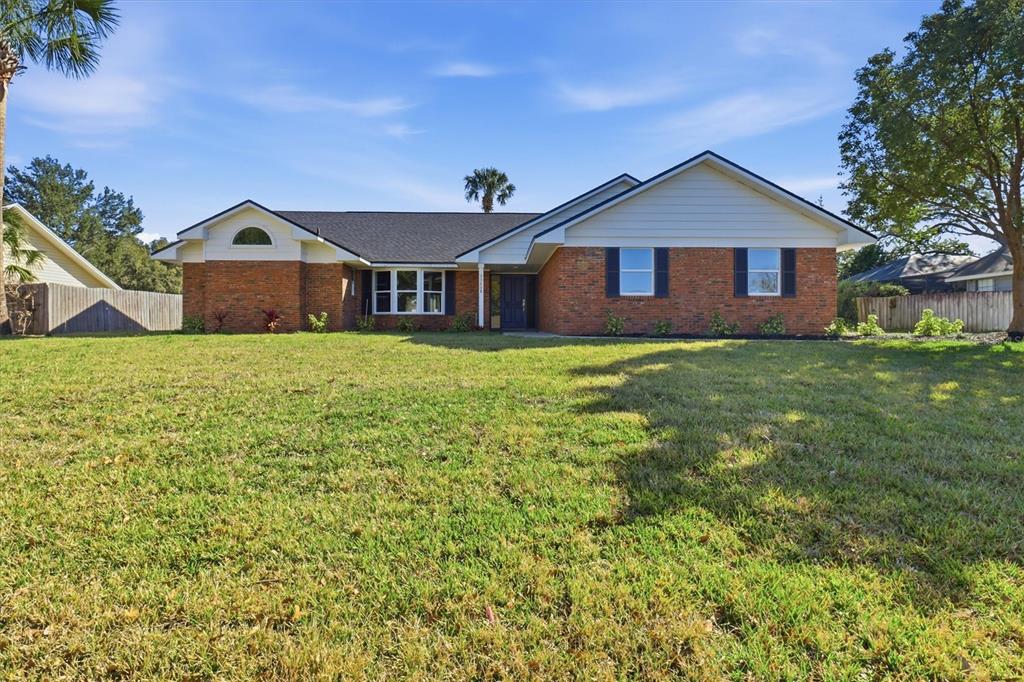 A single-story brick house with a dark roof and a large front lawn — 33608 OVERTON DRIVE, LEESBURG, FL