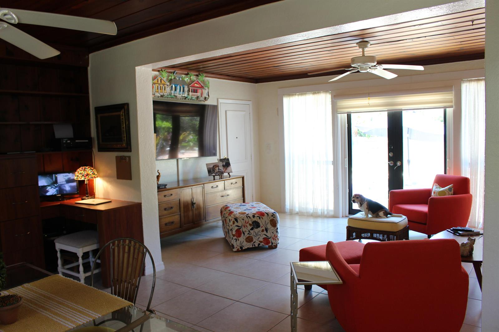A living room features a wooden ceiling, tile floors, orange armchairs, and a beagle dog — 225 Gulfstream Boulevard, Boynton Beach FL 33435, BOYNTON BEACH, FL